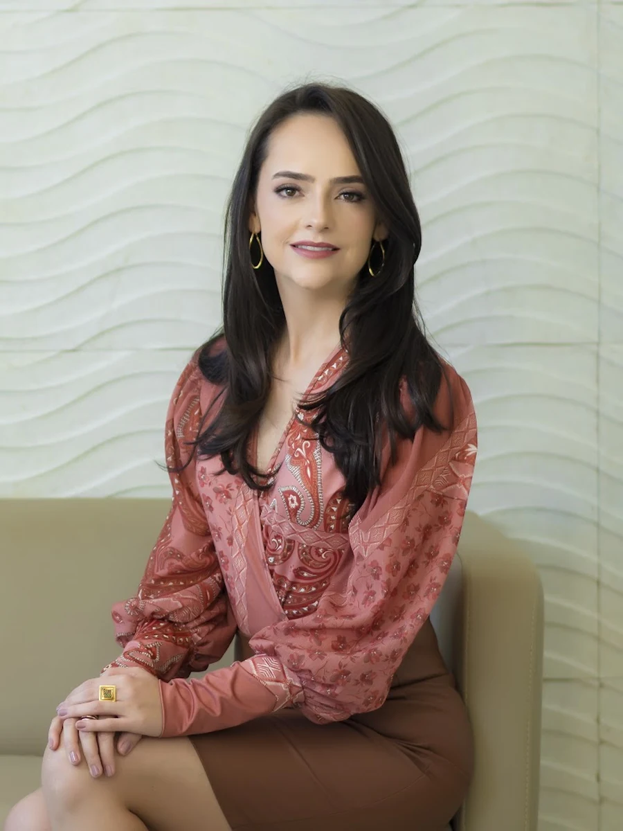 Dra. Lorena Braz sentada no consultório, em Luziânia